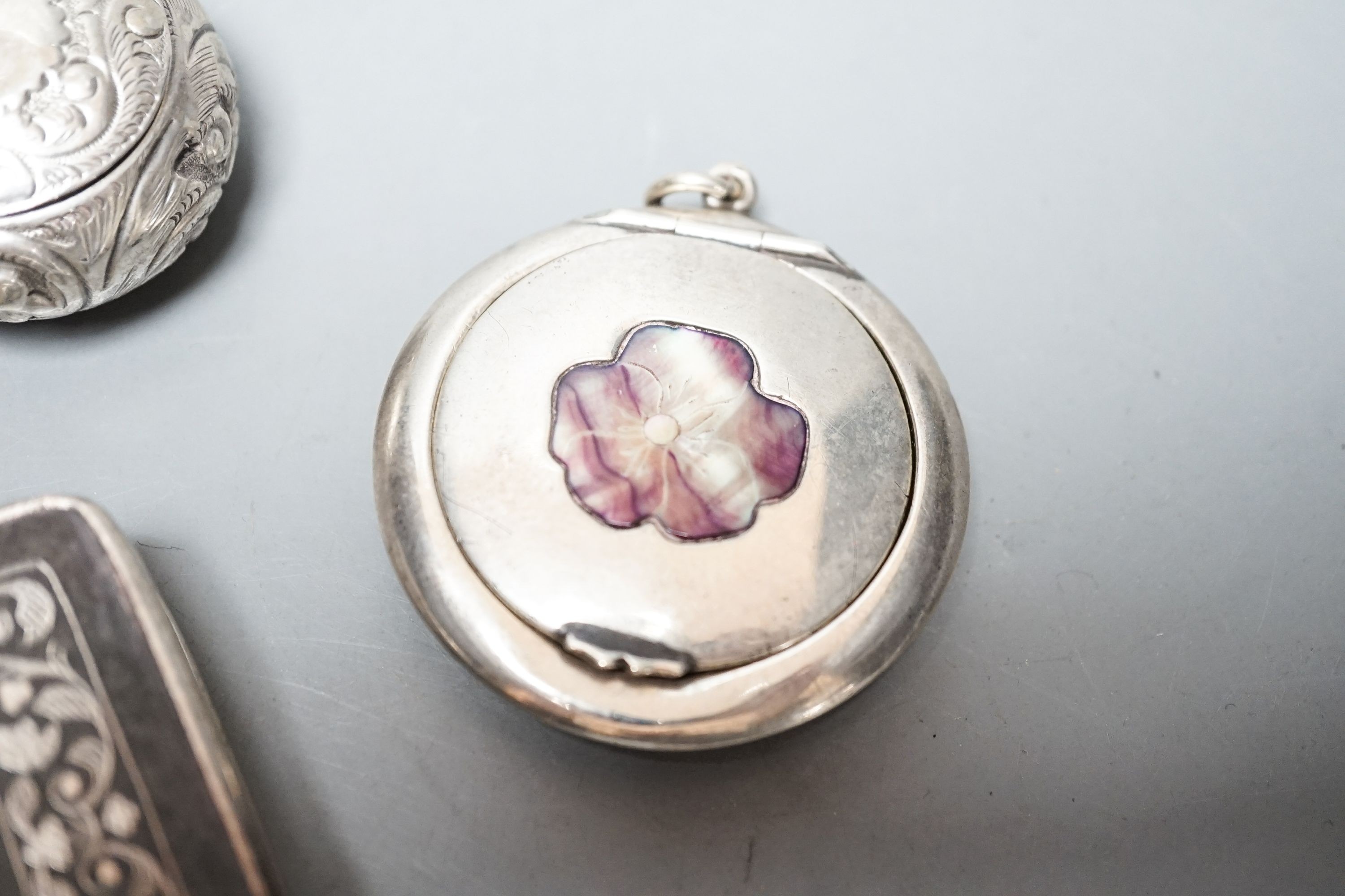 A selection of three small silver or white metal boxes to include a tortoiseshell pique box and a silver and shell inlaid compact.